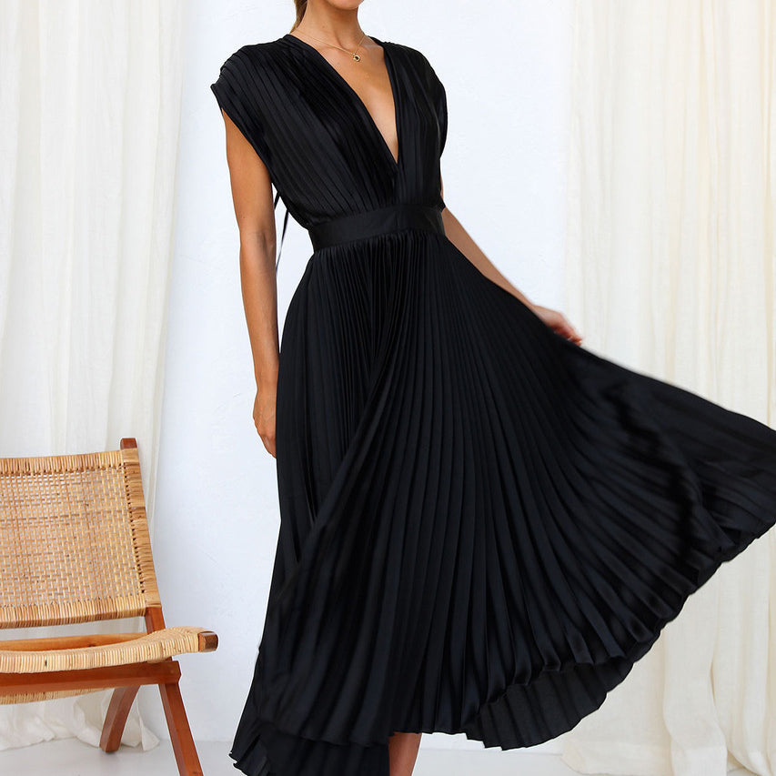 Black pleated dress with the skirt held out to one side.
