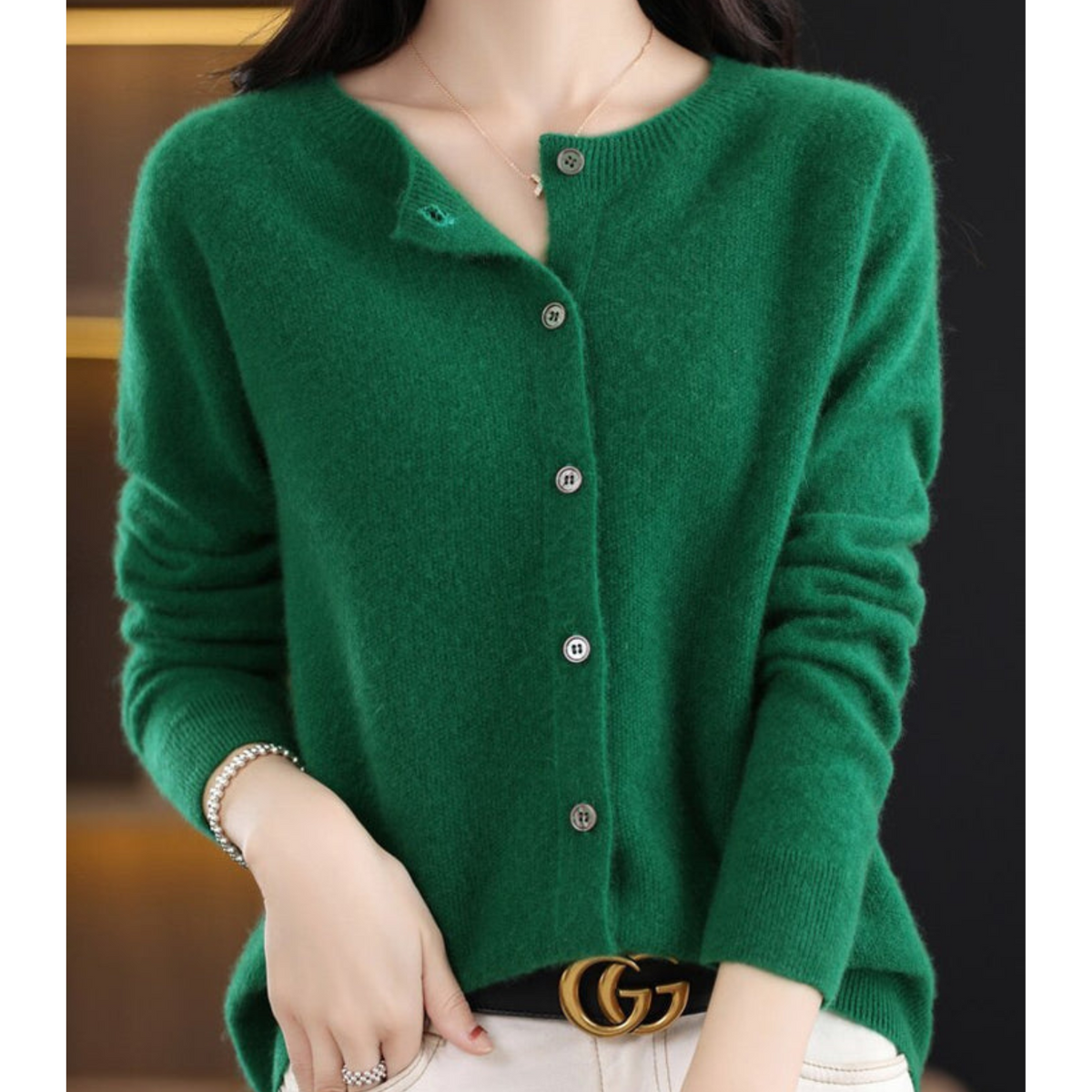 Dark green cardigan with long sleeves and an open top button.