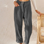 Grey ribbed trousers with side pockets and cuffed hems.