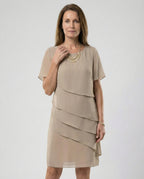 Front view of a khaki layered dress with a round neck, worn with a pearl-style necklace.