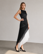 Angled view of the layered black and white dress with its uneven hem.