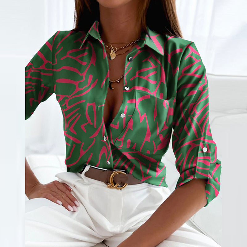 Closer view of the green blouse with pink linear print and a chest pocket.