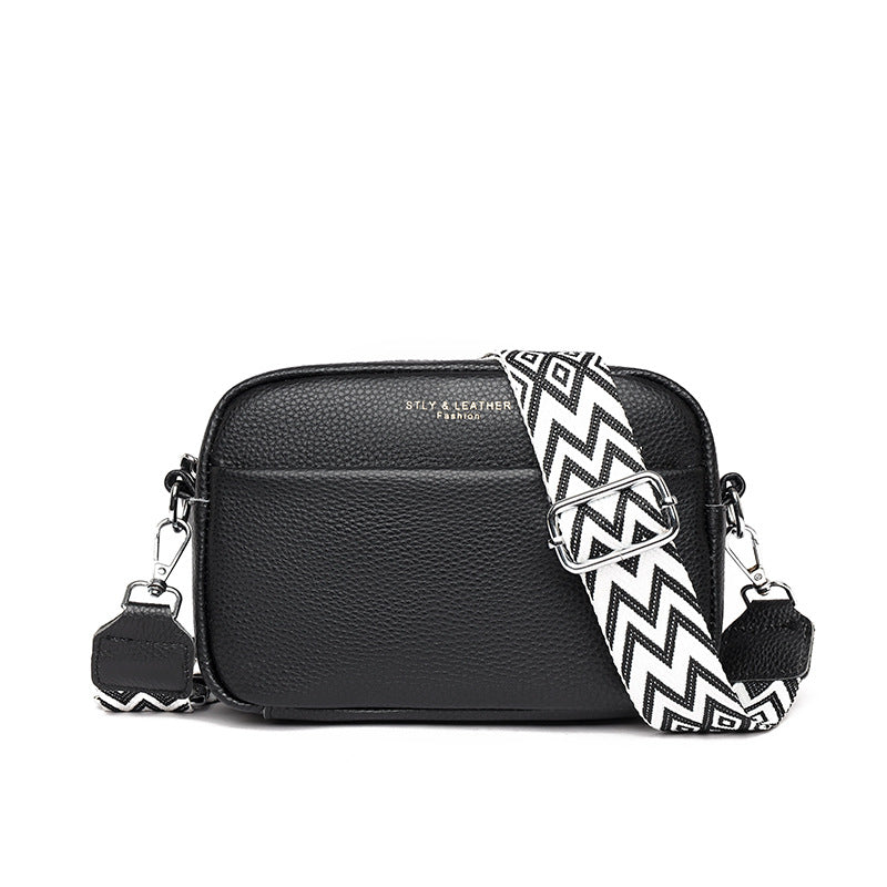 Black shoulder bag with a wide black-and-white strap.