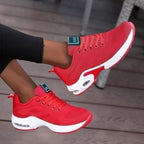 Red trainers with laces and white contrasting sole sections.