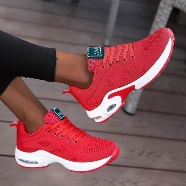 Red trainers with laces and white contrasting sole sections.