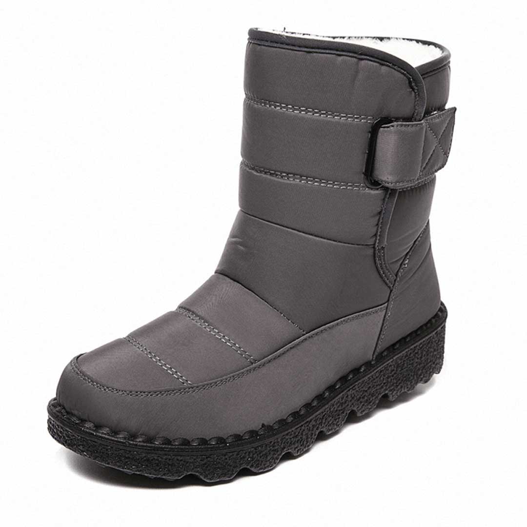 Grey lined winter boot with an upper strap and stitched toe panel.