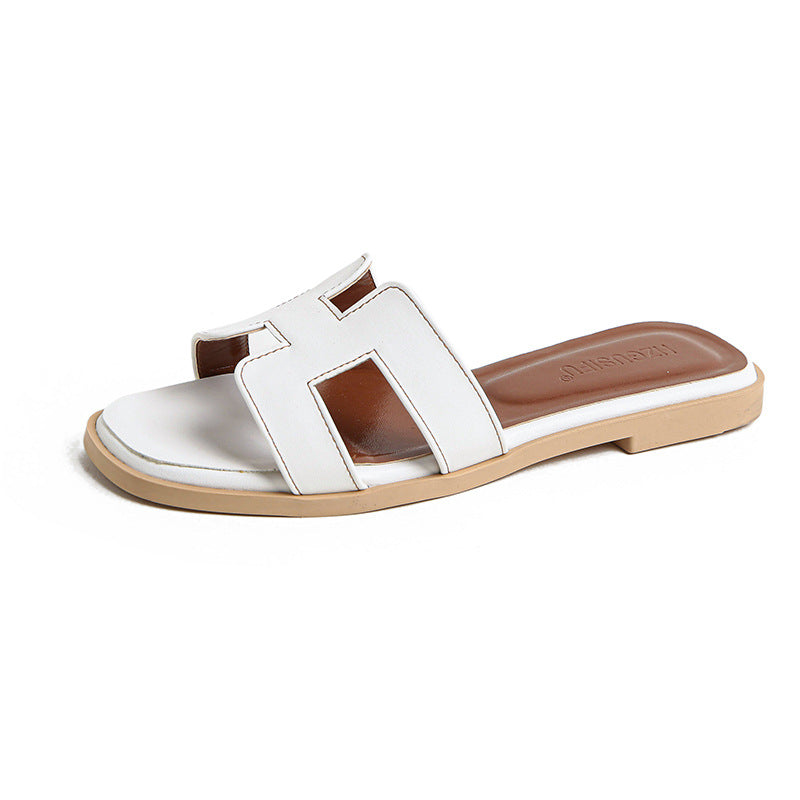 White cut-out slide sandal with a brown footbed and pale sole edge.
