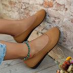 Tan flat shoes with textured uppers shown worn.