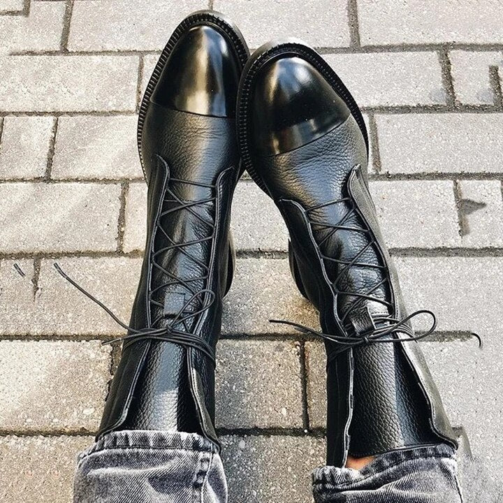 Top view of black boots showing front lacing and rounded glossy toe caps.