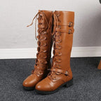 Tan boots with laces threaded through rounded tabs, buckled straps and low heels.