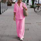 Pink collared shirt with turned-up sleeves and matching full-length trousers.