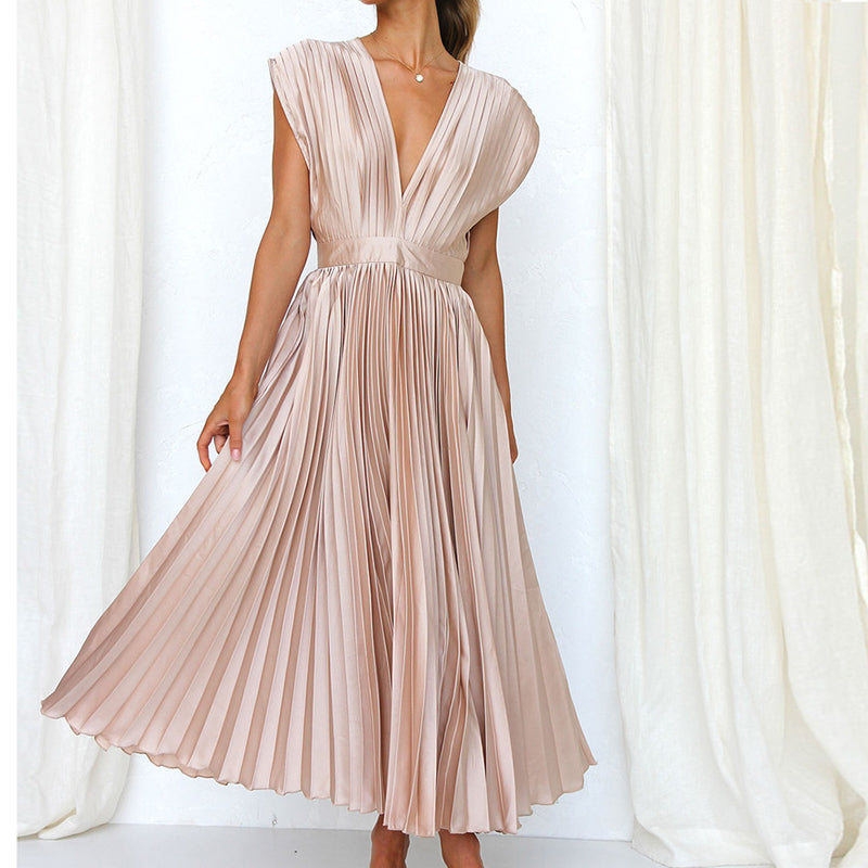 Front view of a champagne dress with a deep V-neck and full pleated skirt.