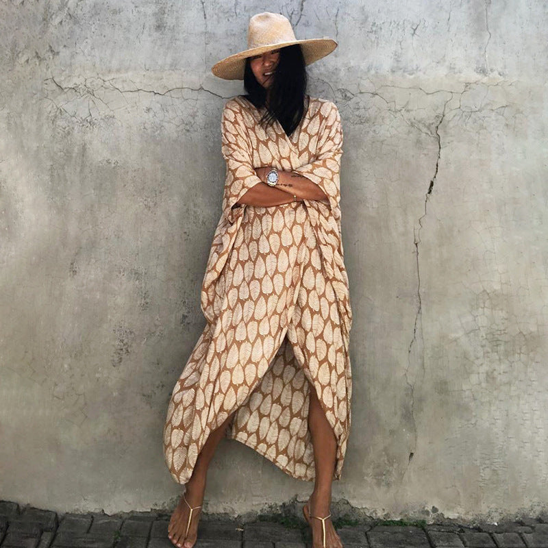 Turmeric-toned leaf-print cover-up worn open at the front.