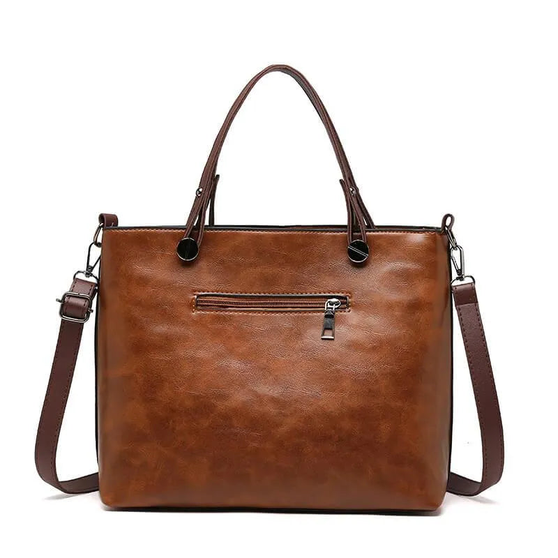 Rear view of the brown handbag with a horizontal zip pocket.