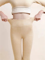 Beige high-waist leggings with the wide waistband held out at both sides.