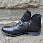 Black ankle boot with a low heel and folded upper.