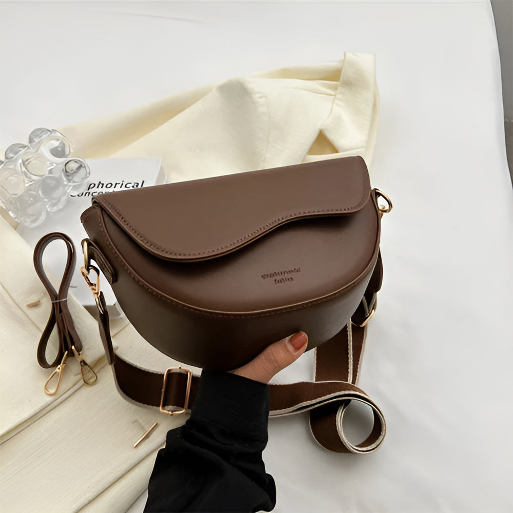 Coffee-brown shoulder bag with a curved flap and adjustable strap.