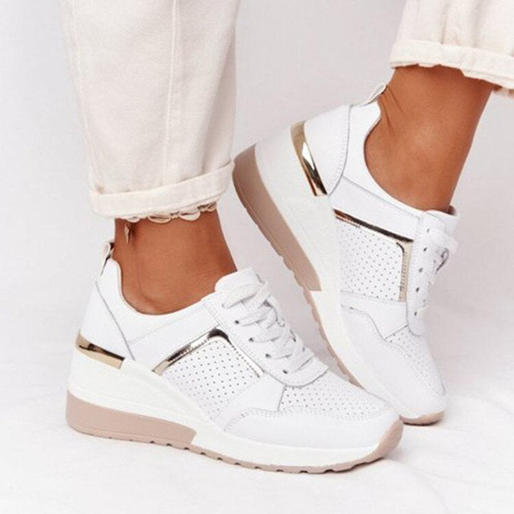 White trainers with perforated panels and metallic side trim.