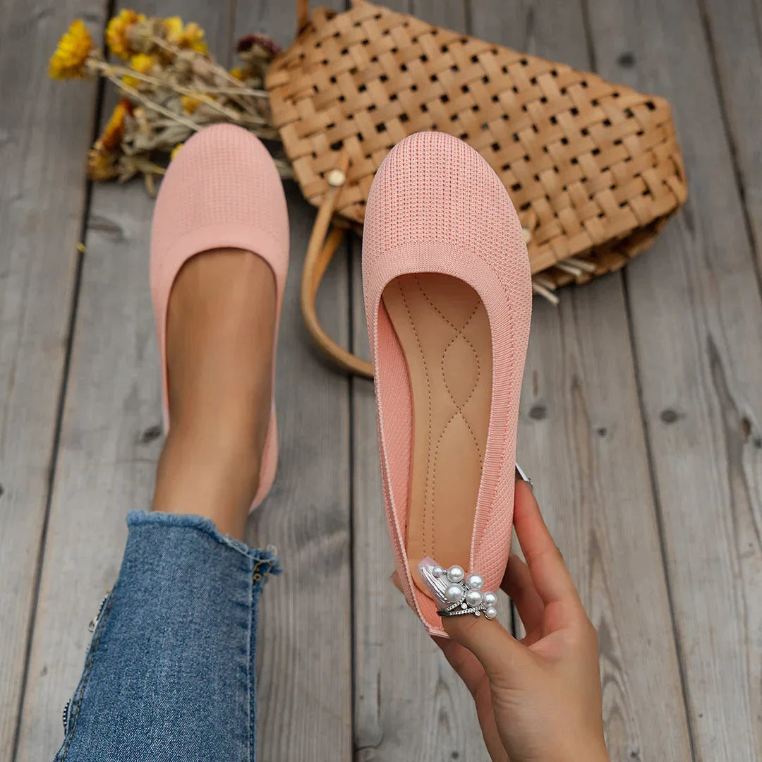 Pink ballet flats shown worn and held.