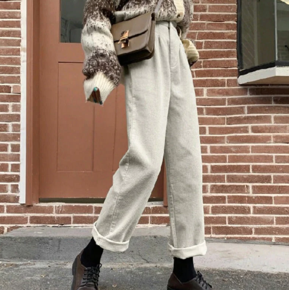 White ribbed trousers with rolled hems, shown outdoors.