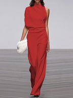 Red jumpsuit with a draped upper section and defined waist.