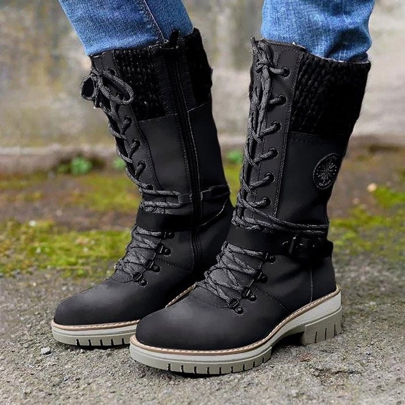 Black lace-up boots with buckled ankle straps and contrasting soles.