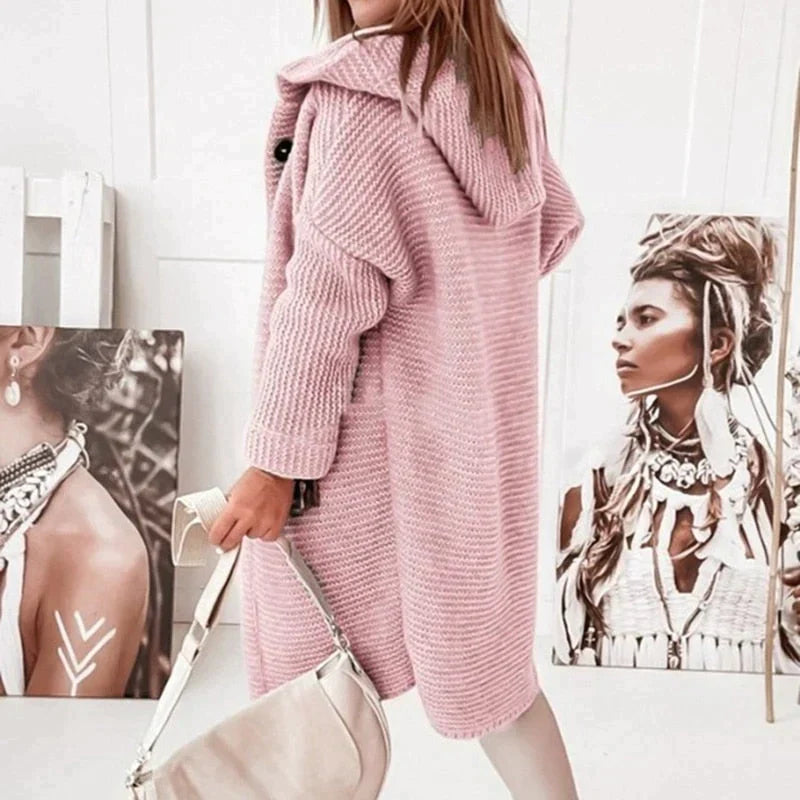 Pink hooded cardigan with ribbed cuffs and a long knit body.