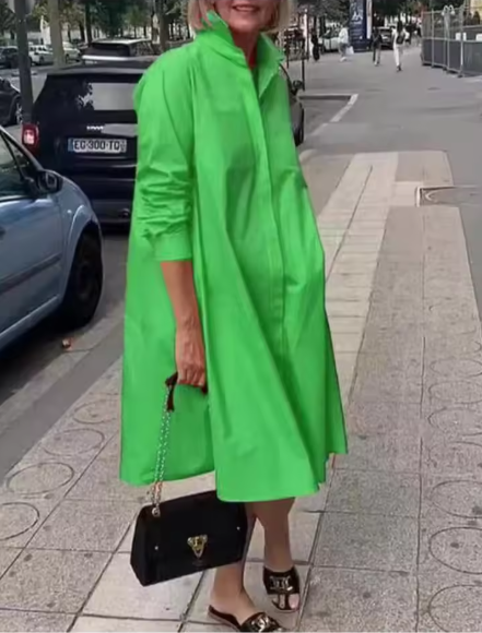 Green collared dress worn outdoors with a small black handbag.