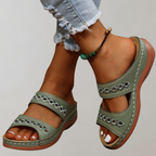 Green slide sandals with diamond-shaped strap cut-outs.