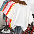 White crew-neck T-shirt on a wooden hanger in front of other colours.
