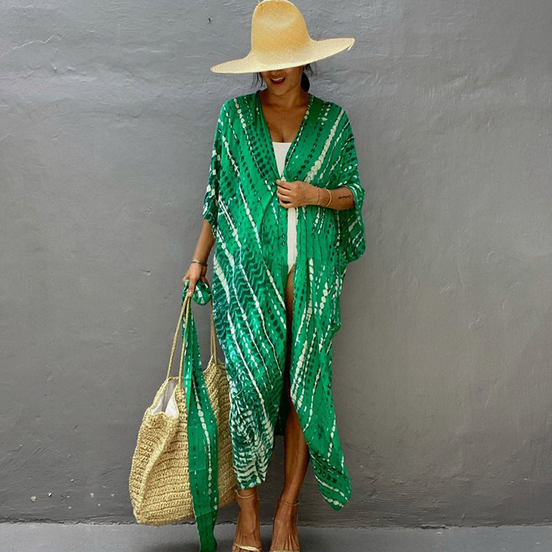 Green printed cover-up over a white swimsuit.