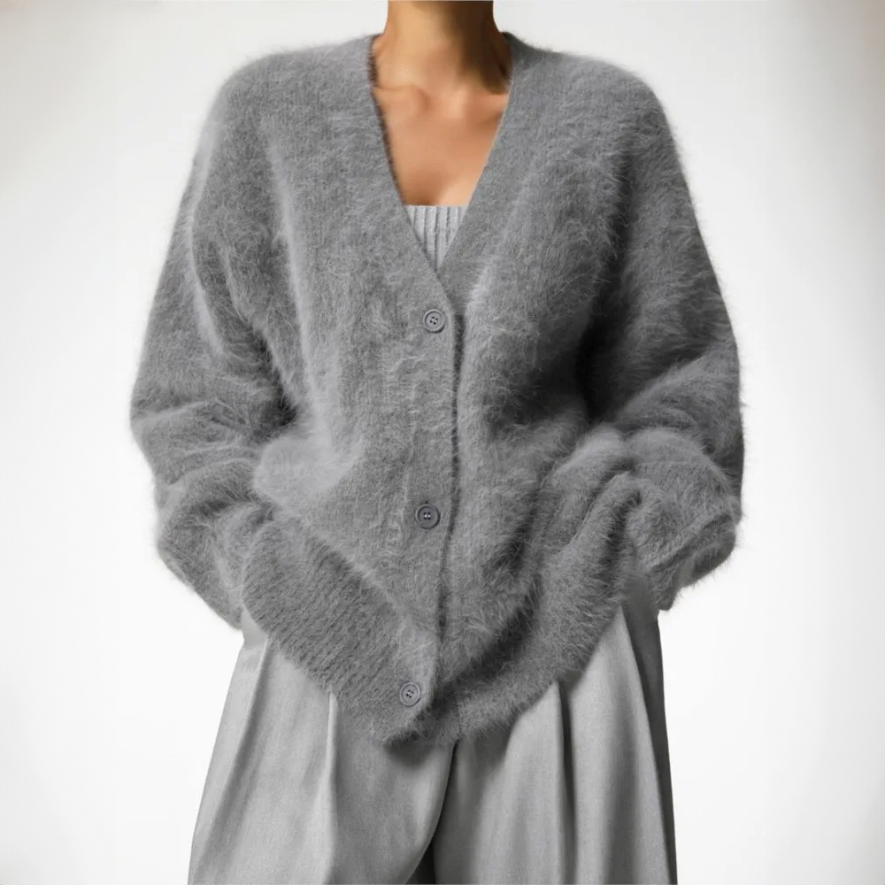 Grey fluffy cardigan with a V neckline, worn over a light top.